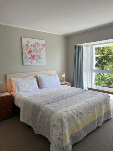 a bedroom with a large bed and a window at Ash Grove Boutique Motel in Paihia