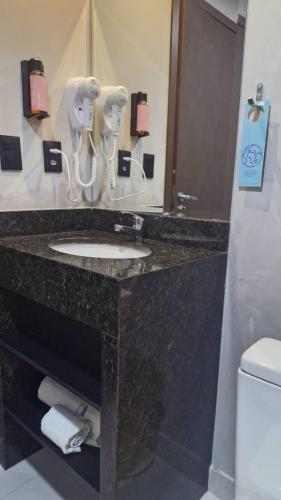 a bathroom with a sink and a mirror at Tulip Inn Bauru in Bauru