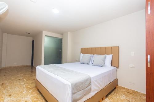 a bedroom with a large bed with white sheets at Hotel Bossanova in Rionegro