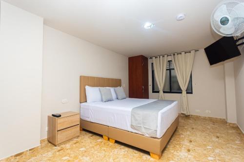 a bedroom with a large white bed and a window at Hotel Bossanova in Rionegro