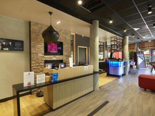 a lobby with a reception desk in a building at ibis Archamps Porte de Genève in Archamps