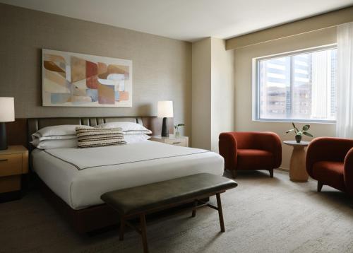 a bedroom with a large white bed and a chair at Kimpton Hotel Palomar Phoenix Cityscape by IHG in Phoenix