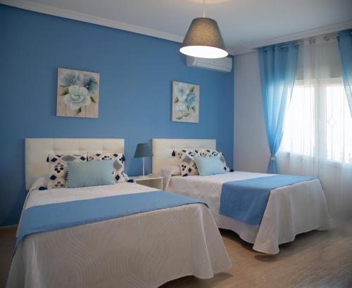 a blue bedroom with two beds with blue walls at Casa Rural La Libélula Azul in Polán