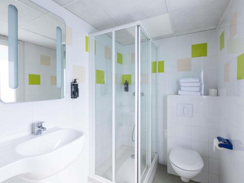 a bathroom with a shower and a toilet and a sink at ibis budget Angoulême Centre in Angoulême