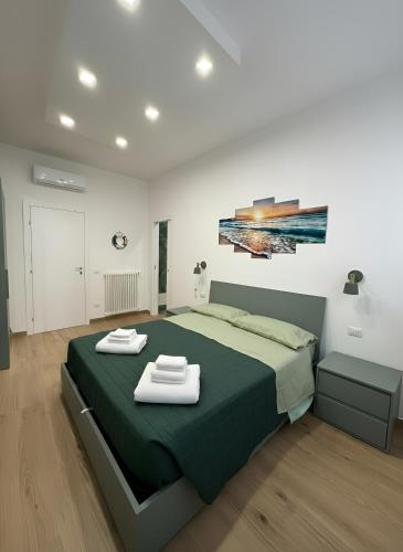a bedroom with a green bed with two towels on it at CIAO PARTENOPE - luxury rooms in Naples