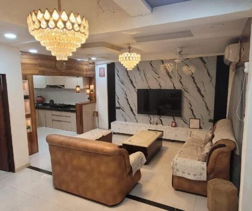 a living room with two couches and a flat screen tv at Avenaa Villa Rahul Residency Ganeshpeth Nagpur in Nagpur