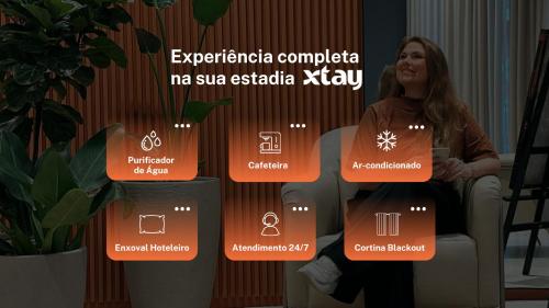 a woman sitting in a chair next to a wall with a diagram at Xtay Oslo Florianópolis – Estúdios com rooftop no Centro in Florianópolis