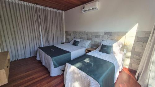 a hotel room with two beds and a window at Vila Encantada – Ponta de Pedras in Ilha Arapiuns