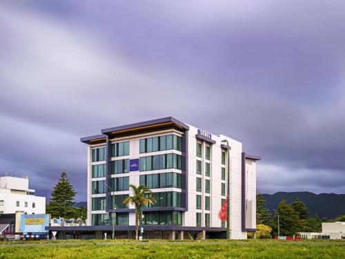a building with a palm tree in front of it at The Sebel Wellington Lower Hutt in Lower Hutt