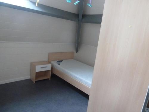 a small room with a bed and a night stand at Gîte du Tronquoy in Aix-en-Ergny
