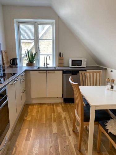a kitchen with a table and a sink and a window at F27-1 3 people, 3 bedrooms, fully furnished in Aalborg