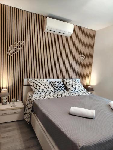 a bedroom with a bed with a striped wall at Étape premium confort avec parking et entrée privative in Sassenay
