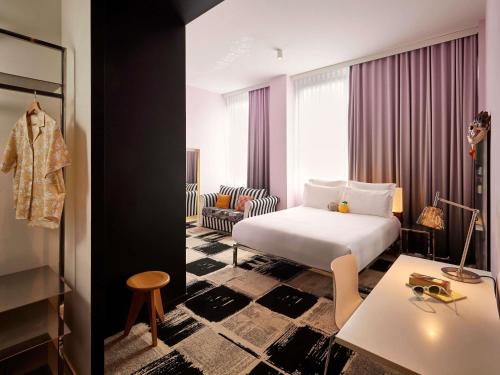 a hotel room with a bed and a table at Mama Shelter Bordeaux Centre in Bordeaux