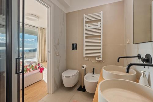a bathroom with two sinks and a toilet at Lantern Penthouse in Salerno
