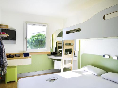 a dorm room with a bunk bed and a desk at Ibis Budget Perpignan Nord Rivesaltes in Rivesaltes