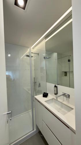 a white bathroom with a sink and a shower at Timeless - O`Clock in Lisbon