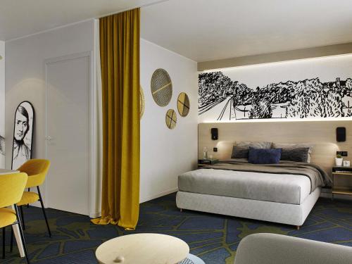 una camera da letto con un letto e un dipinto sul muro di Mercure Agen Centre a Agen