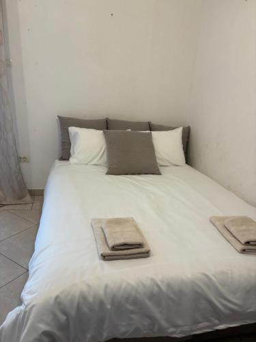 a white bed with two towels on top of it at Apartman Solis in Igalo