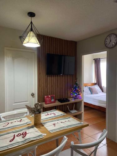 a living room with a table and a bed at GusBek Condo Unit San Remo Oasis Cebu in Cebu City
