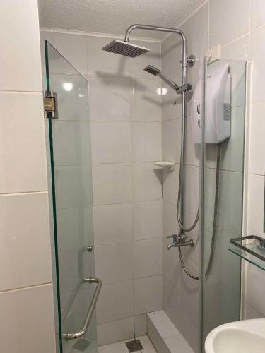 a bathroom with a shower with a glass door at GusBek Condo Unit San Remo Oasis Cebu in Cebu City