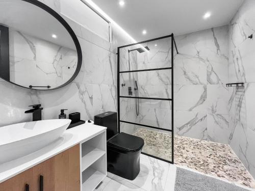 Un baño con lavabo blanco y ducha. en Hyde Park 1 Your Comfy Apt With Parking in San Juan, en San Juan