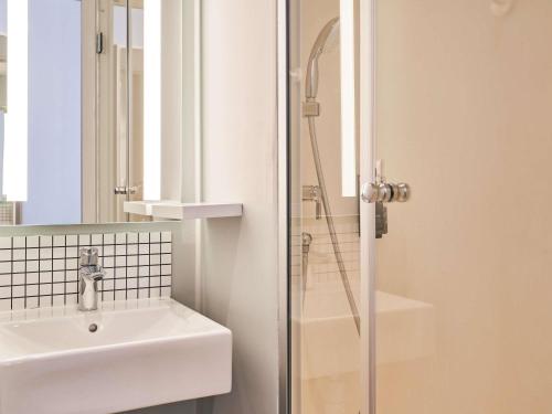 un baño con lavabo y ducha en ibis budget Saint-Maurice, en Saint-Maurice