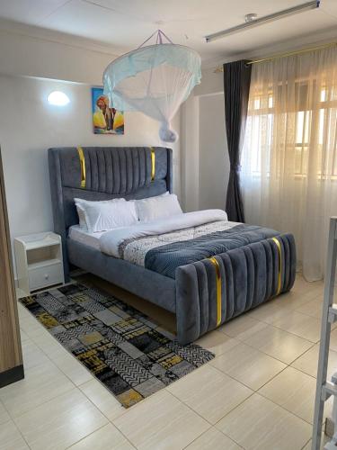 a bedroom with a large bed with a blue headboard at Elite suite 1bedroom in Busia