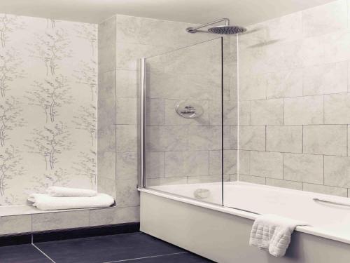 un bagno con doccia e vasca da bagno di Mercure Thame Lambert Hotel a Chinnor