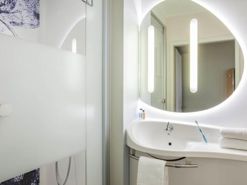 a bathroom with a sink and a mirror at Ibis Budget Mulhouse Centre Gare in Mulhouse