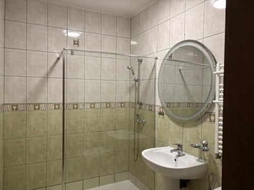 Un baño con ducha, lavabo y espejo. en Gościniec Witomino, en Gdynia