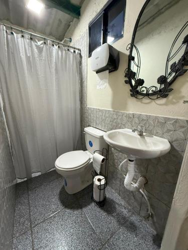 a bathroom with a toilet and a sink at Villa San Carlos in Juayúa