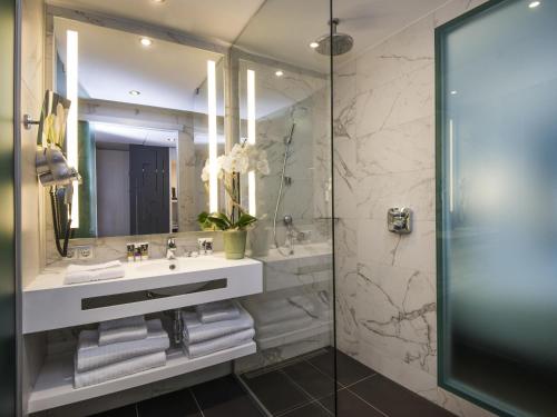 a bathroom with a sink and a mirror at Mercure Ajaccio in Ajaccio