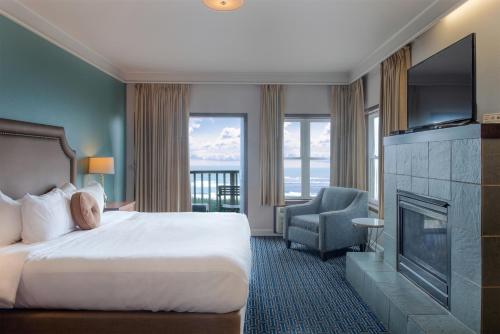 a hotel room with a bed and a fireplace at Inn at Nye Beach in Newport