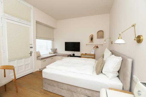 a white bedroom with a large bed and a desk at Apartment am Michel mit Parkplatz in Hamburg