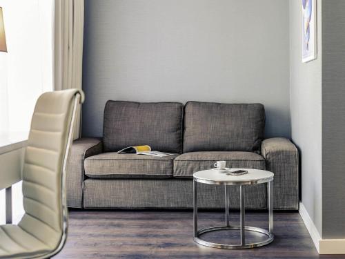 a living room with a couch and a table at Mercure Hotel Raphael Wien in Vienna