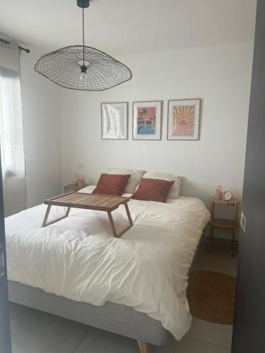 a bedroom with a bed with a table on it at T2 cosy au calme , proche Dax in Tercis-les-Bains