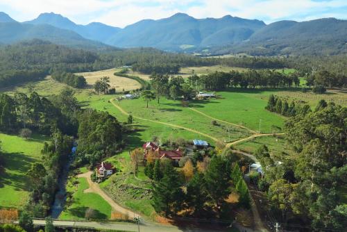 an aerial view of a farm with mountains in the background at Crabtree House in Huonville