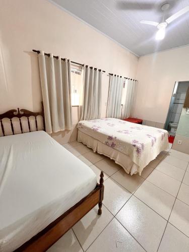 ein Schlafzimmer mit zwei Betten und einem Fenster in der Unterkunft casa da hilda in Pirenópolis