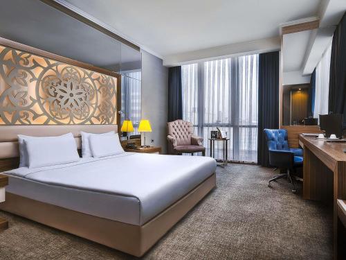 una camera d'albergo con un letto e una scrivania di Downtown Ankara Hotel a Ankara