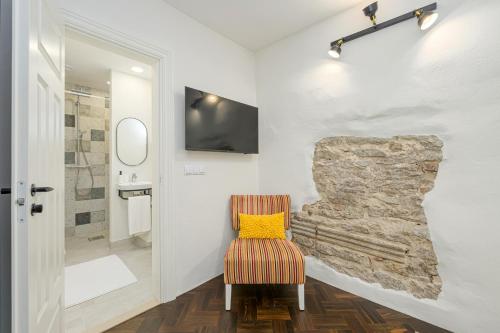 Una silla con una almohada amarilla en un baño. en Tallinn Old Hanza Apartments, en Tallin