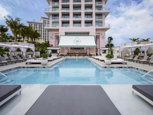 a swimming pool in front of a tall building at SLS at Baha Mar in Nassau