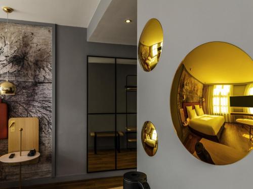 ein Hotelzimmer mit einem großen Spiegel an der Wand in der Unterkunft Mercure Saint Omer Centre Gare in Saint-Omer