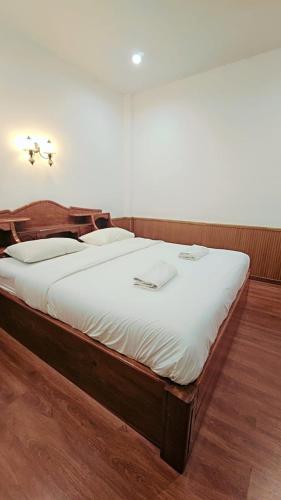 a large bed in a room with white sheets at Home 24 Pattaya in Pattaya