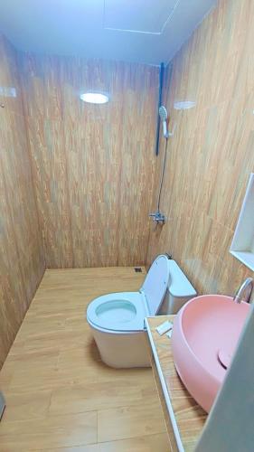 a bathroom with a pink toilet and a sink at Home 24 Pattaya in Pattaya