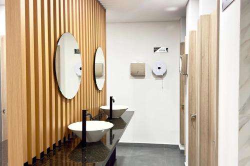 a bathroom with two sinks and two mirrors at Apartamento completo en Sabaneta in Sabaneta