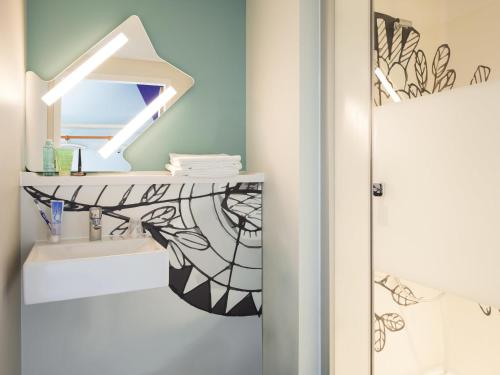 un baño con lavabo y espejo en ibis budget Fribourg, en Fribourg