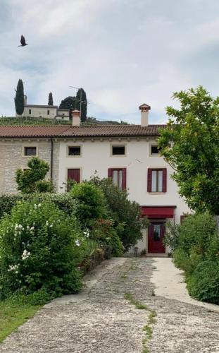 a large white house with a red door at Casa Agostini Bed and Breakfast in Farra di Soligo
