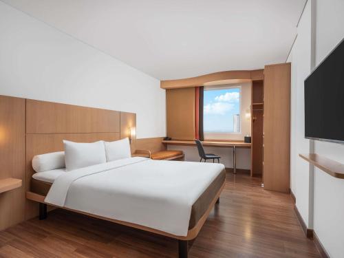 a hotel room with a bed and a desk at Ibis Gading Serpong in Serpong
