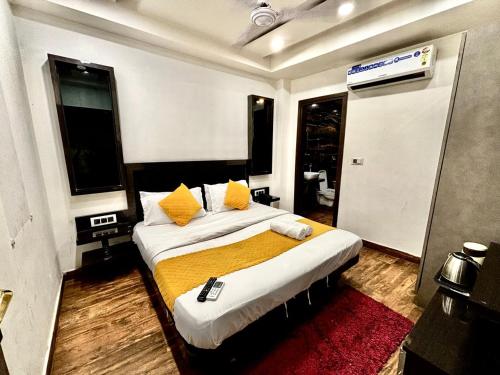 a bedroom with a large bed with yellow pillows at Hotel Red Stone - 3 Mins from Railway Station and 5 Mins from Metro in New Delhi