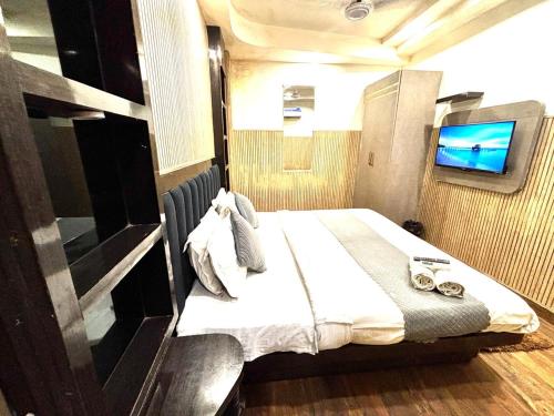 a bedroom with a bed and a tv in it at Hotel Red Stone - 3 Mins from Railway Station and 5 Mins from Metro in New Delhi